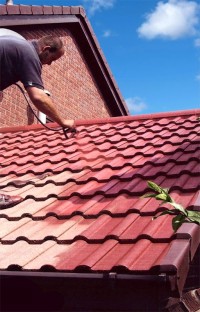 Applying paint, with a 10 year guarantee,  to a roof. Roof painting by G M Services, Cork, Ireland